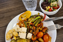 Hier sieht man einen vollen Teller mit Essen. Darauf befindet sich eine große Auswahl an Gemüse getoppt mit Feta Käse.